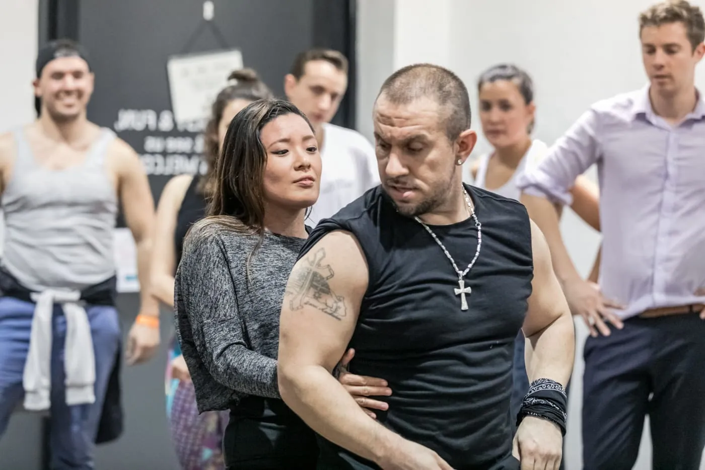 Jaime Jesus leading a partner through a salsa figure while a class watches
